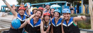 Lachende groep mensen tijdens het waterskiën bij Terhills Cablepark.